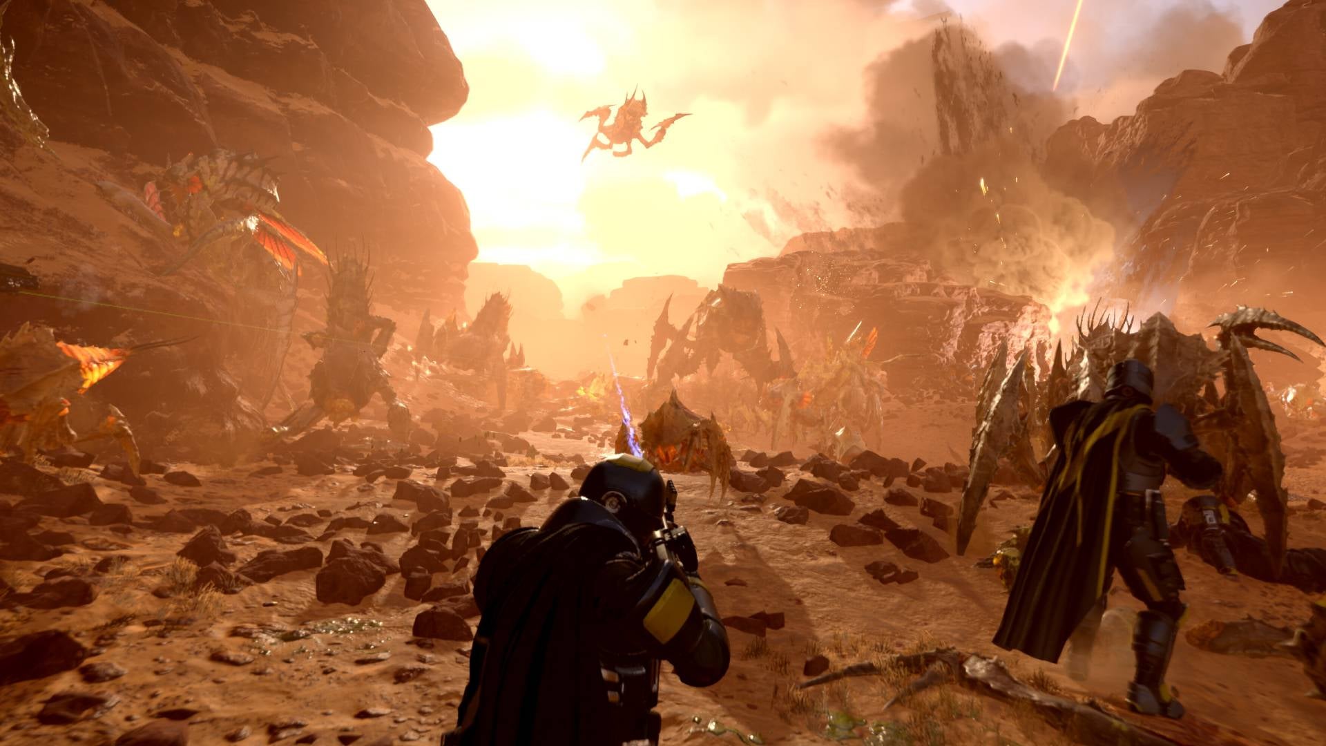 A Helldiver on a rocky planet firing at Terminids in a canyon with another Helldiver fighting a bug up close to the right.