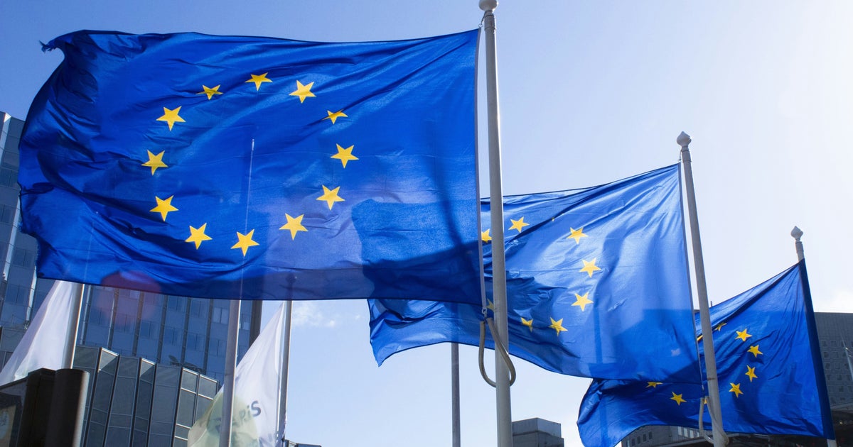 European Union flags waving outside the European Commission building in Brussels representing the EU antitrust approval of the 55 billion EA acquisition