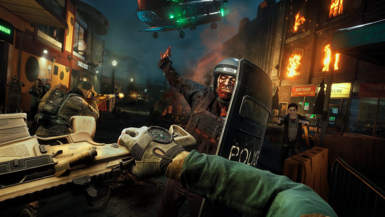 Players pushing toward an extraction point with a helicopter overhead and fires burning in the background