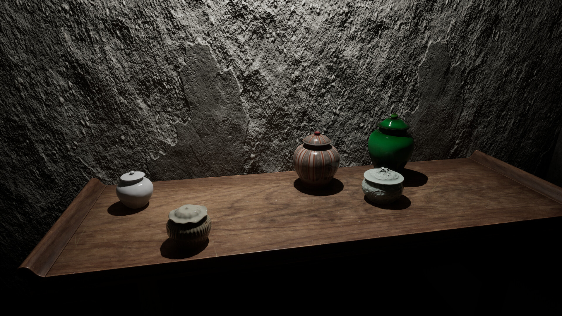 Five ceramic jars arranged on a wooden table against a textured wall